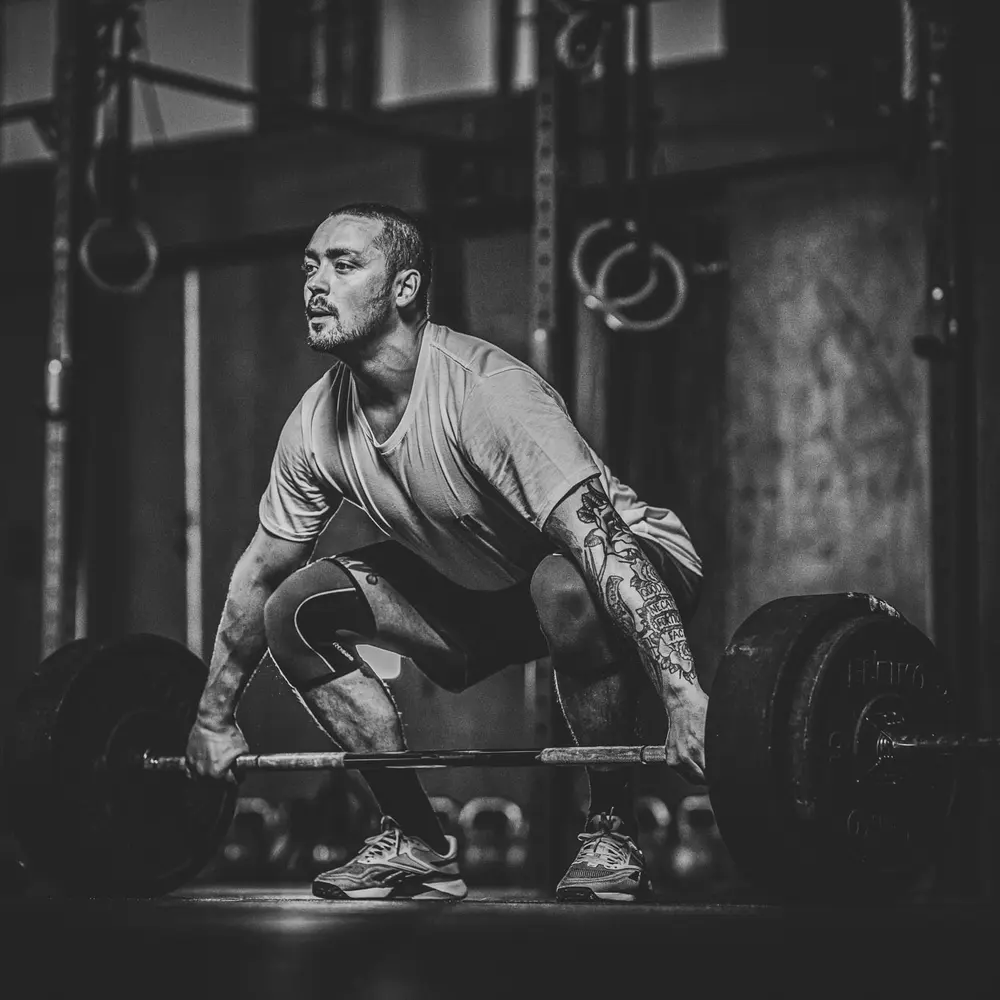 An athlete setting up a heavy barbell pull.